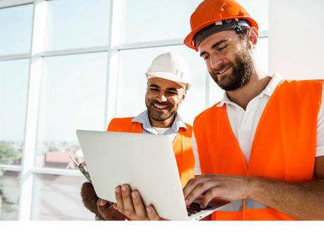 two tradesmen looking at laptop