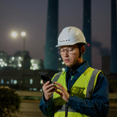 man looking at his phone at plant