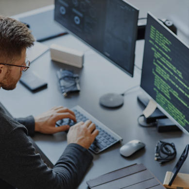 man looking at dual screen