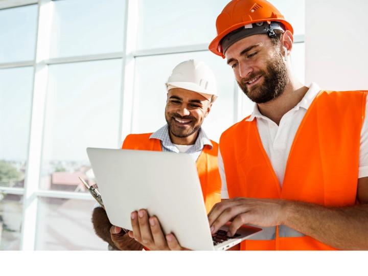 two tradesmen looking at laptop